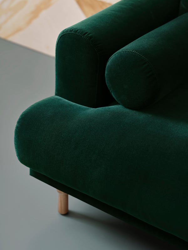 A close-up of the soft lines and voluminous dark green cushions on the LÅNGARYD two-seat sofa.
