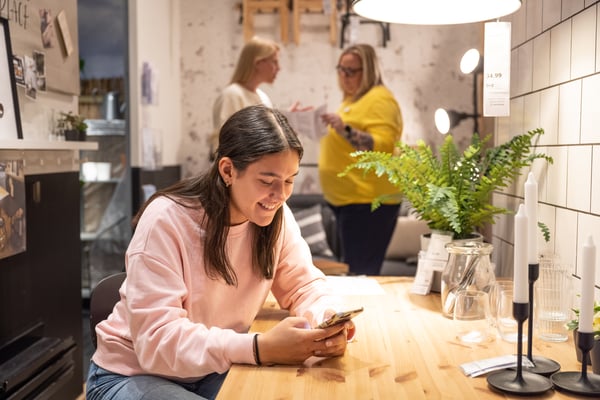 A girl looking at her phone in an IKEA store