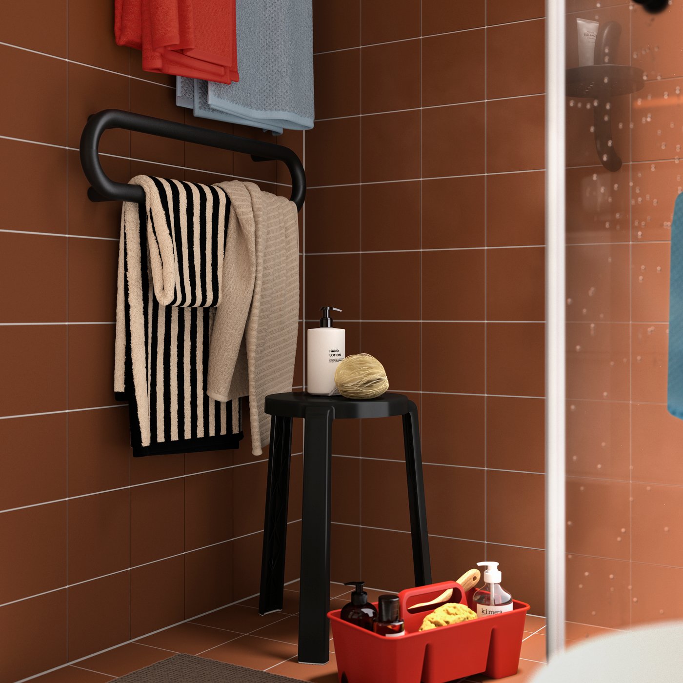 A black and beige striped SLÅNHÖSTMAL bath towel, draped on a black towel rail in a terracotta-tiled bathroom.