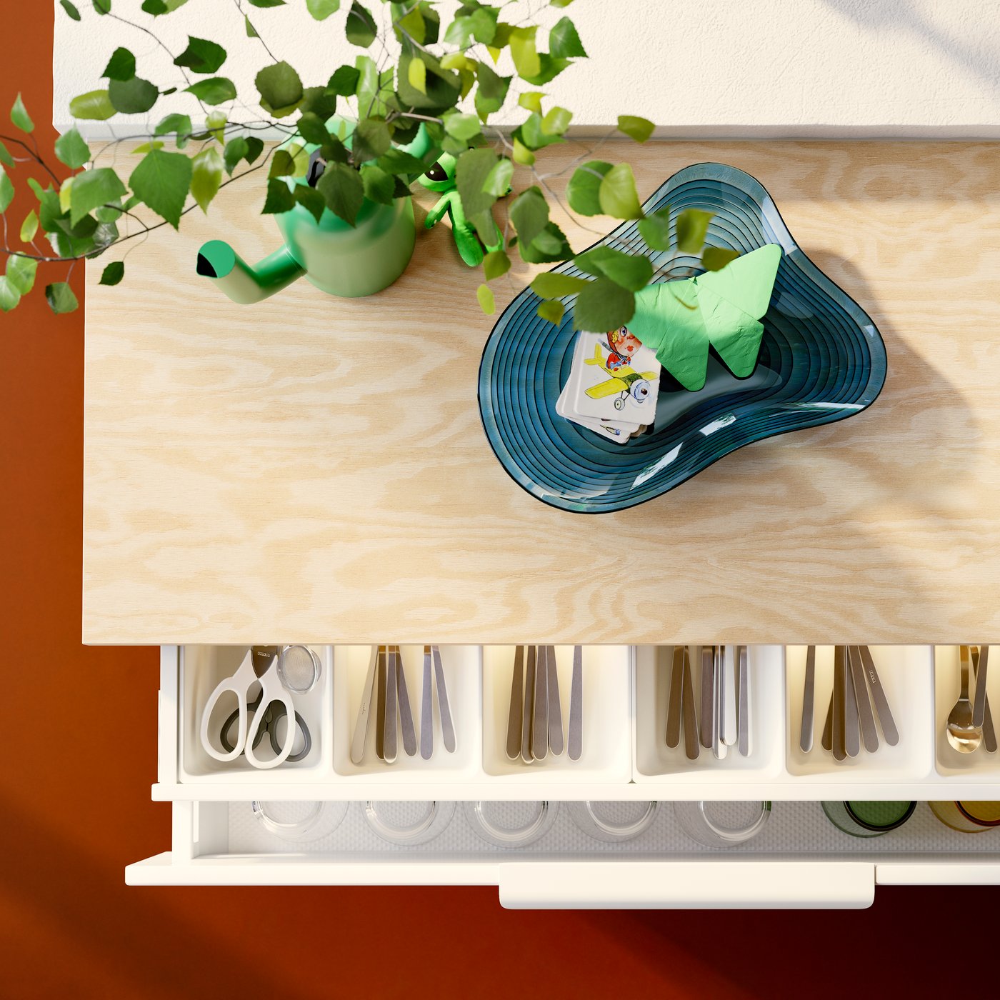 Kitchen storage with VEDDINGE white drawer fronts open, displaying UPPDATERA cutlery trays holding diverse cutlery items.
