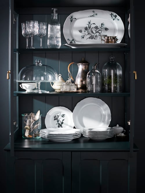 UPPLAGA porcelain and SÄLLSKAPLIG cut glassware mixed with glass, cutlery and metal jug on a wooden open dresser.