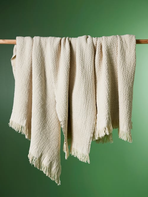 Bathroom featuring an off-white LAPPTÅG throw made from cotton and wool, hanging on a wooden-like item.