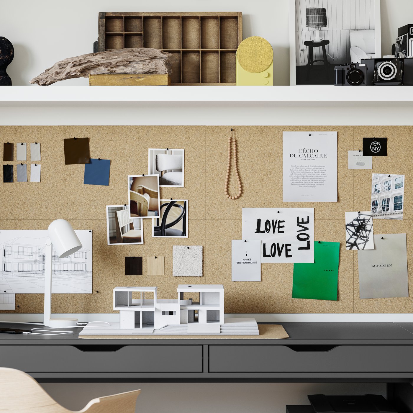 Gros plan sur un bureau ALEX bleu noir installé sous un panneau d’affichage mural en liège. Enceinte jaune sur une étagère.