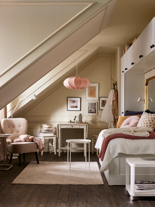EIn Schlfzimmer mit Dachschräge, Hängelampen aus unserer REGNSKUR Serie und weiteren Accessoires für ein gemütliches Ambiente.