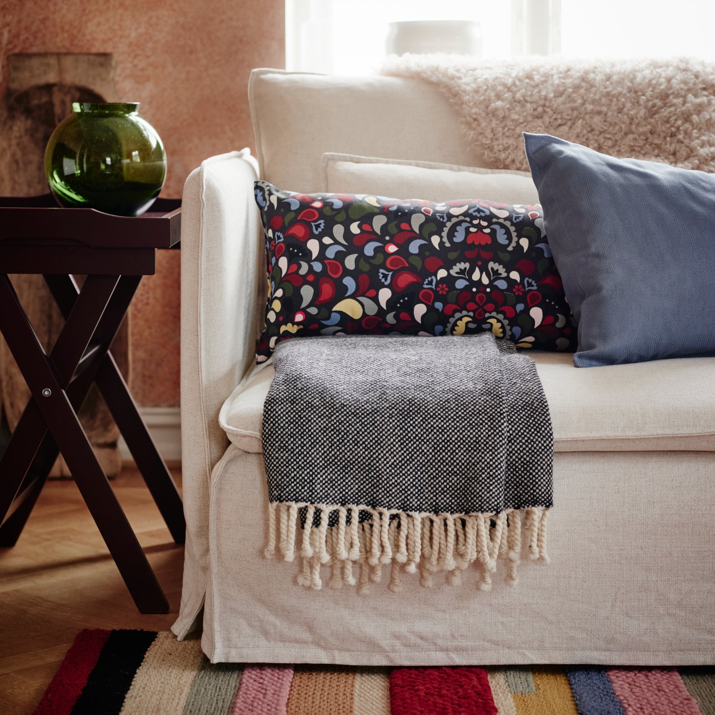 An anthracite/multicolour SLÅNMOTT cushion