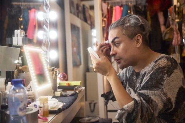 Envy i sit omklædningsrum, hvor hun lægger makeup foran sit spejl.