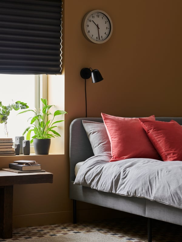 A black SKURUP wall lamp in the bedroom
