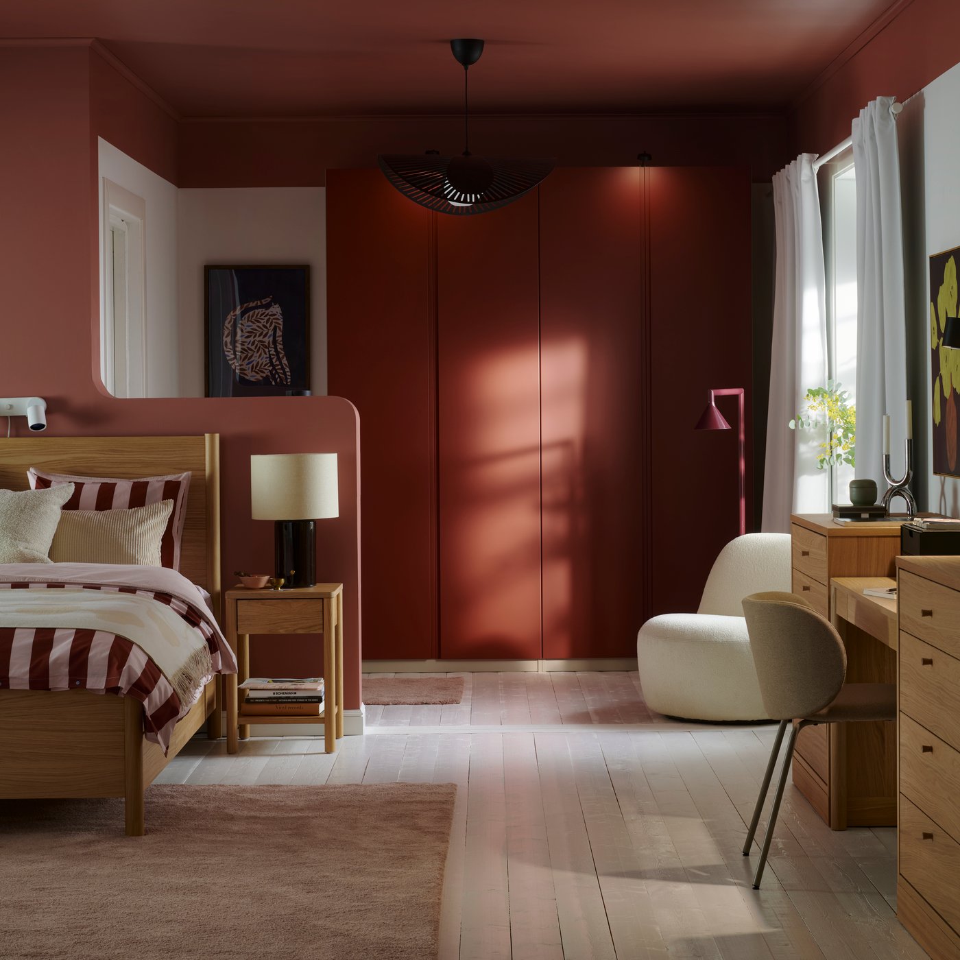A bedroom with white floors and an oak veneer TONSTAD bed with striped bedding and PAX wardrobe with orange VIKANES doors.