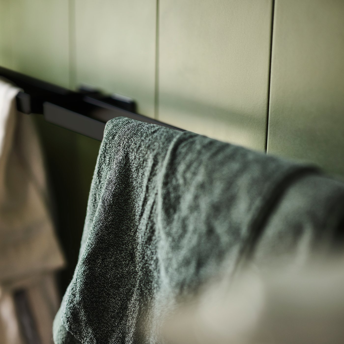 A dark green/mélange HIMLEÅN bath towel in the bathroom