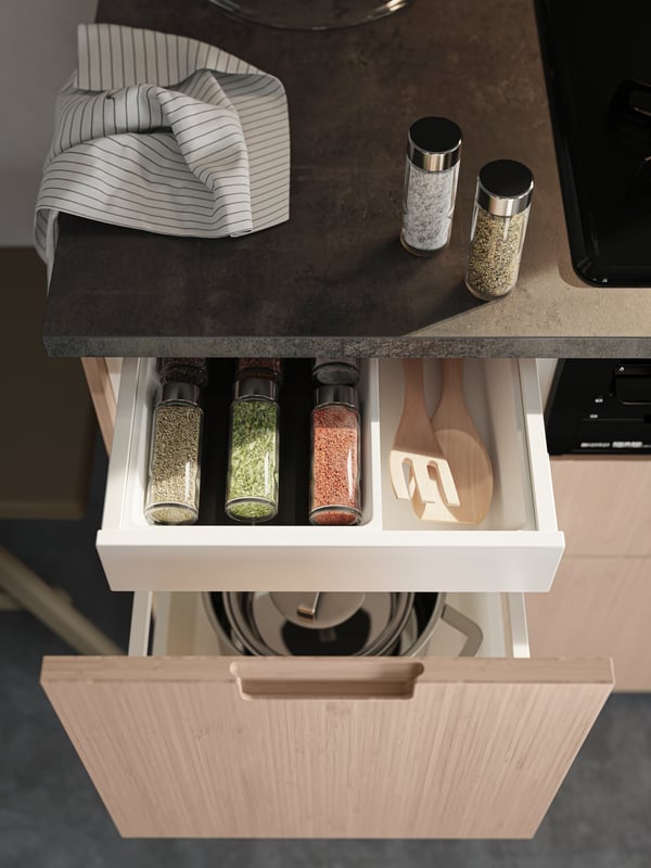 Close up of open kitchen drawers with FRÖJERED fronts in light bamboo