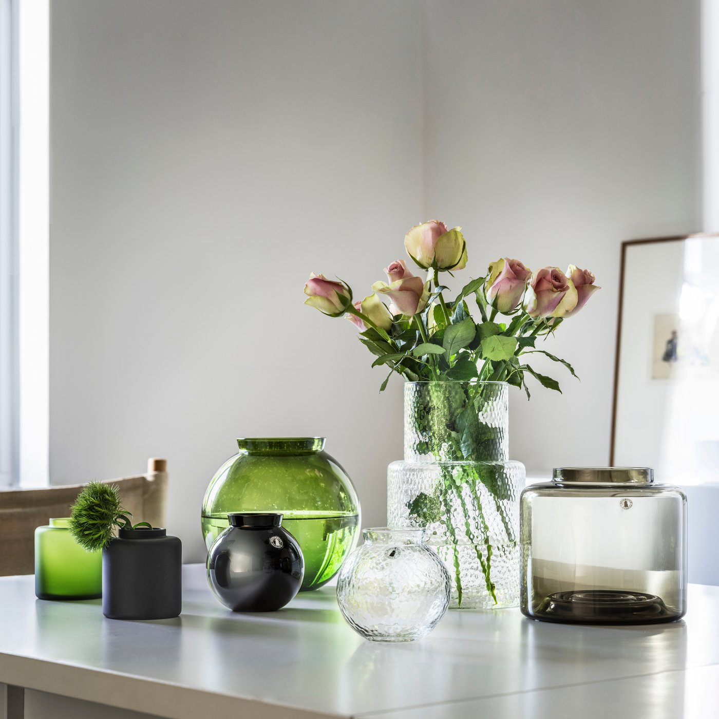 Large collection of KONSTFULL vases on a clear white table top.