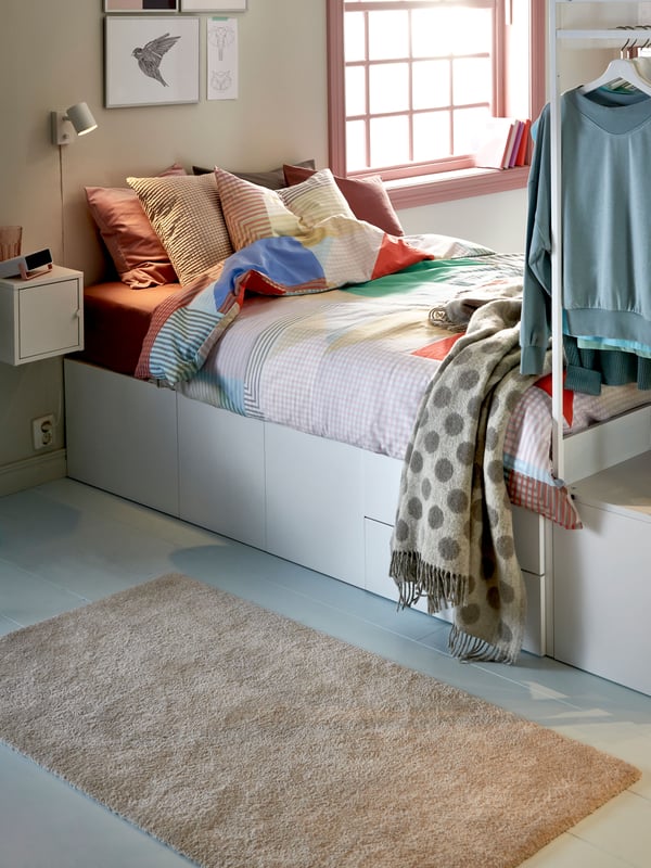 A beige RÅVAROR throw in the bedroom