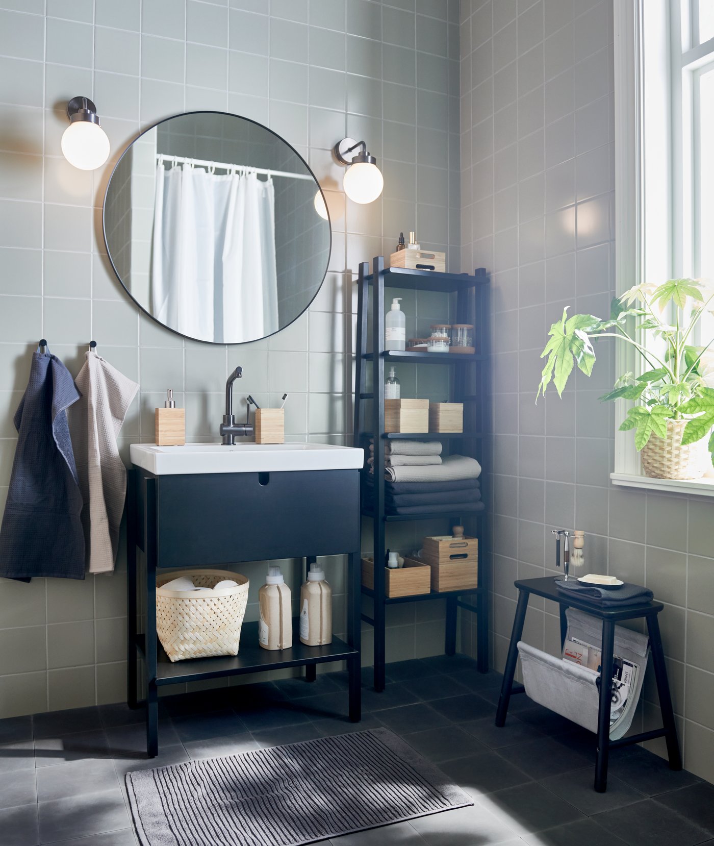 A black VILTO storage stool in the bathroom