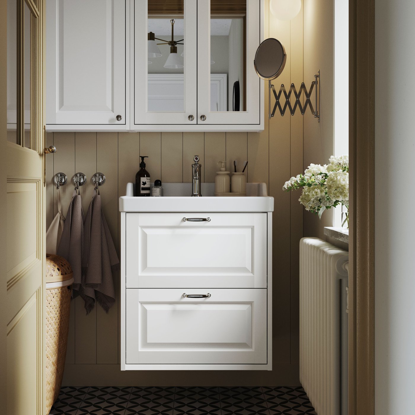 A white TÄNNFORSEN wash-stand with drawers and a matching mirror cabinet are placed in a bathroom with light brown walls.