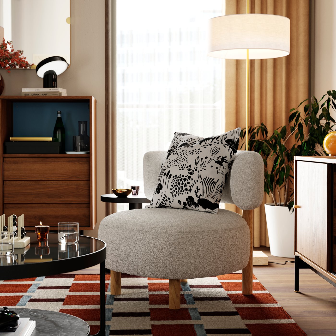 A cushion with a STOCKHOLM 2025 cushion cover lies on a STOCKHOLM 2025 armchair next to a FRÖTORP coffee table.