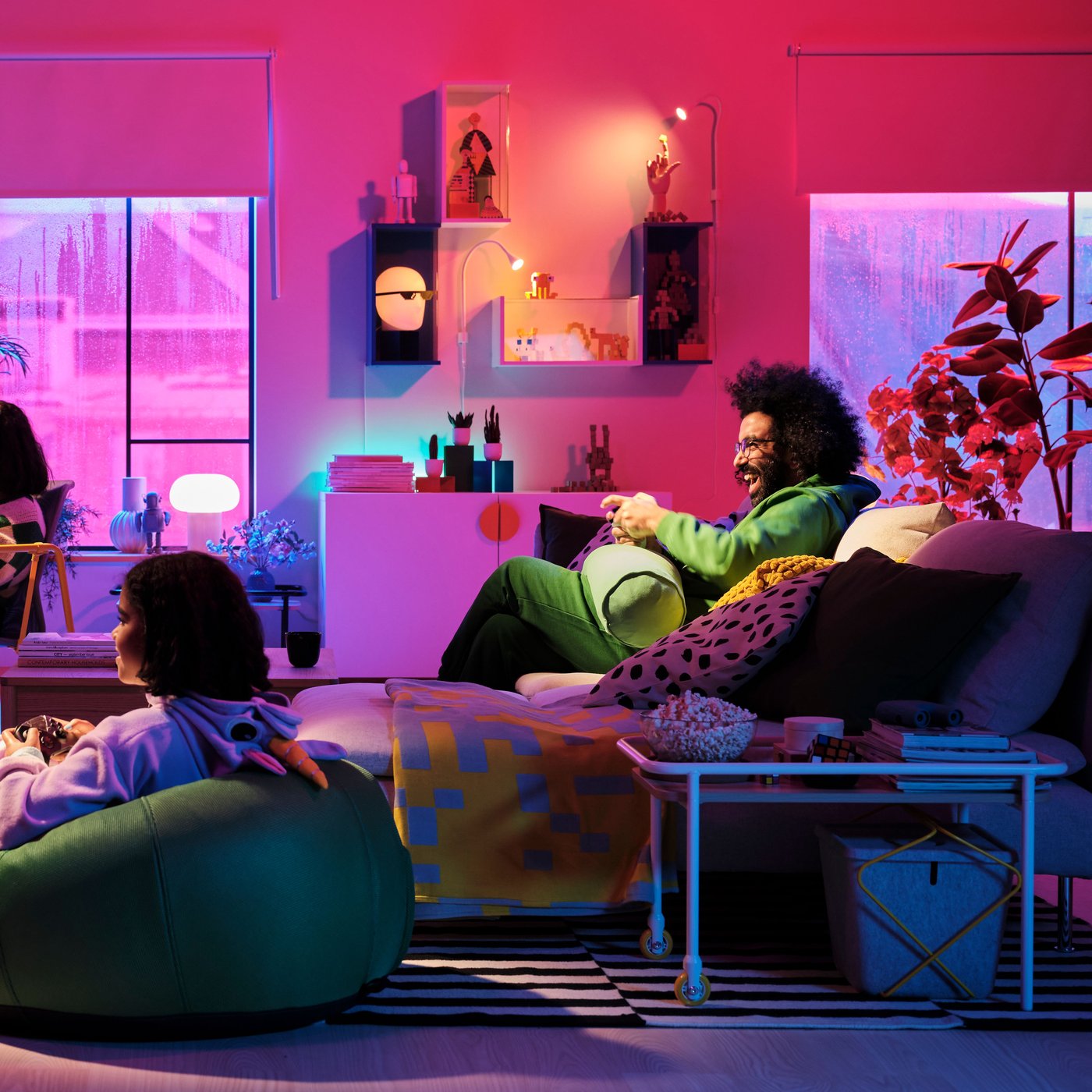 People relaxing on sofas, playing on a game console