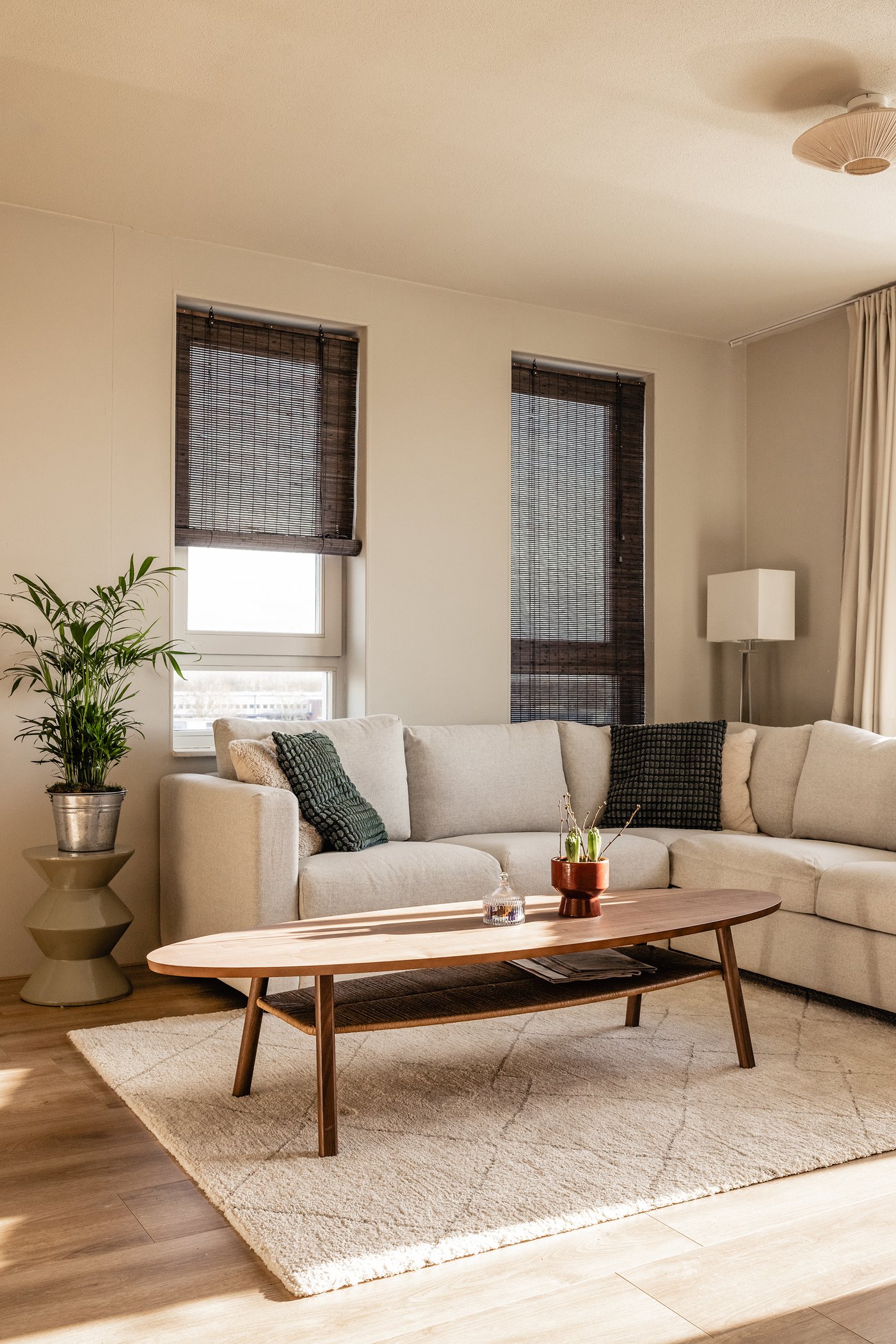 Hoek van een woonkamer met VILME hoekbank in Gunnared beige. Hiervoor staat een STOCKHOLM salontafel op een beige TVERSTED vloerkleed.