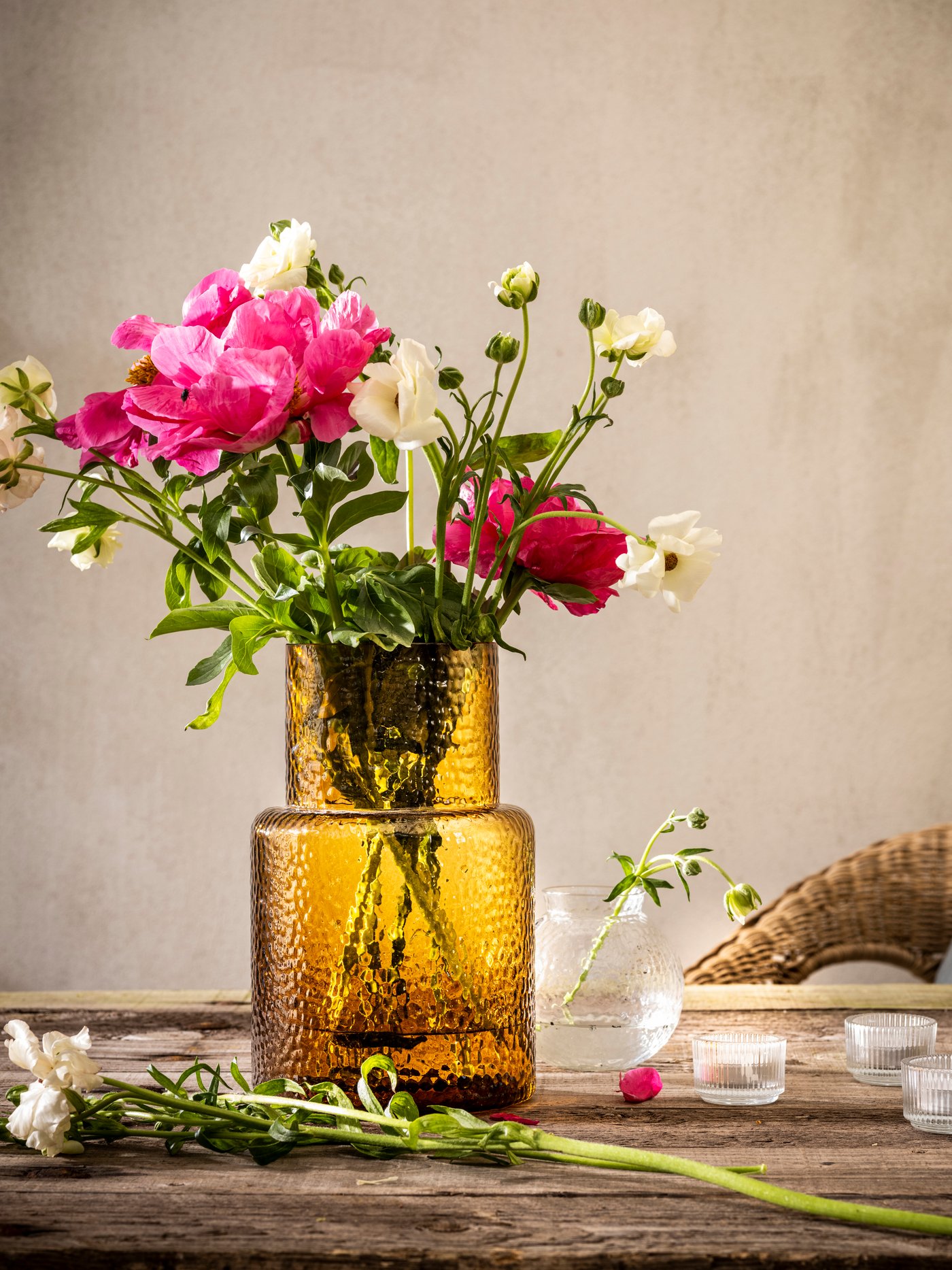 Un tavolo con fiori dentro un vaso fantasia/marrone KONSTFULL. 