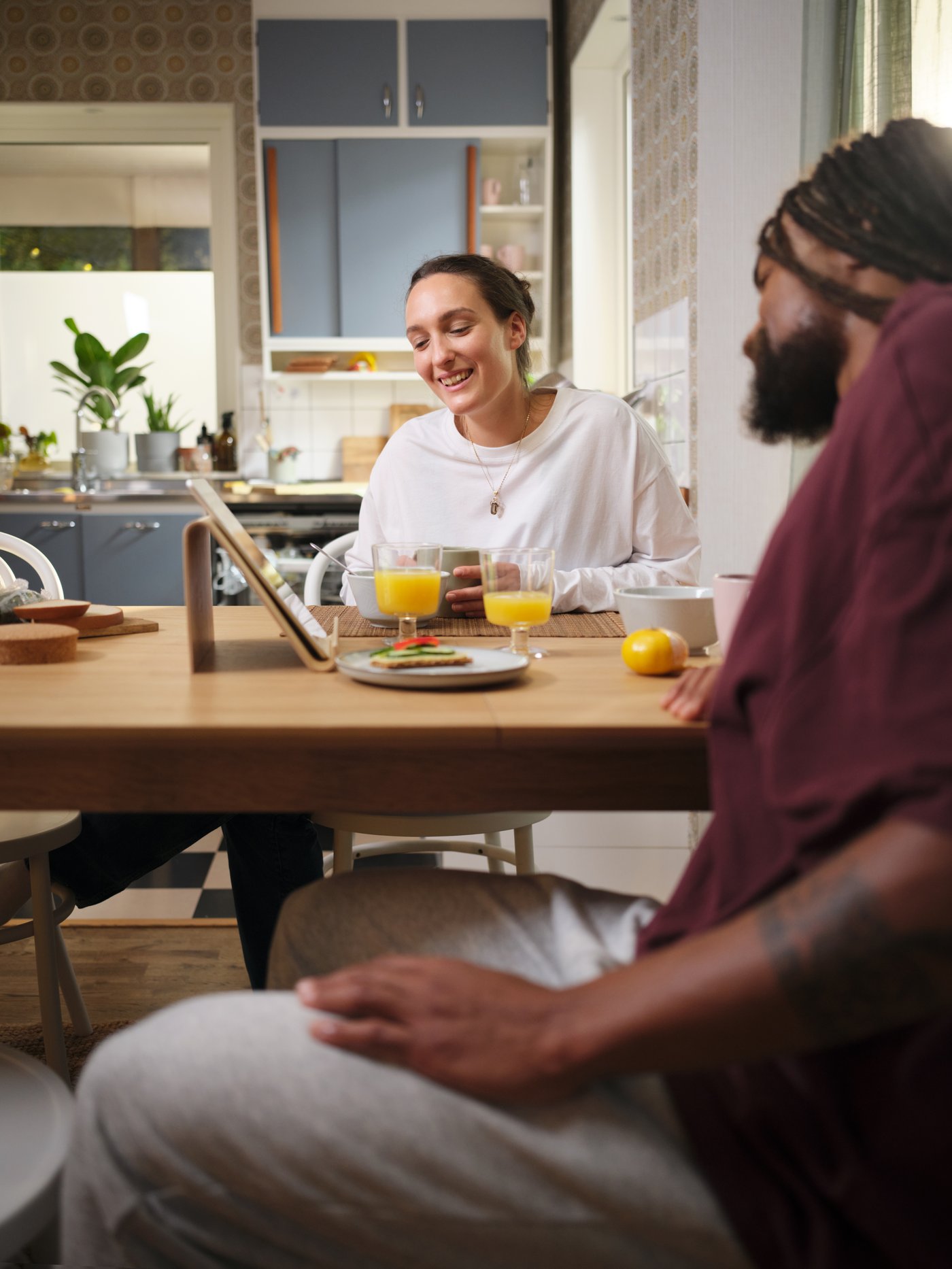 A couple is designing their BESTÅ storage unit in the BESTÅ planner on their tablet.