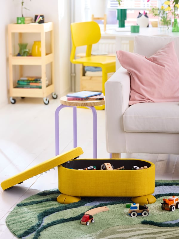 An yellow GREJSIMOJS pouffe with storage in the NA