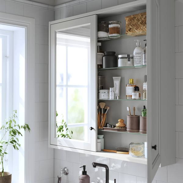 A light grey TÄNNFORSEN mirror cabinet with doors in the bathroom