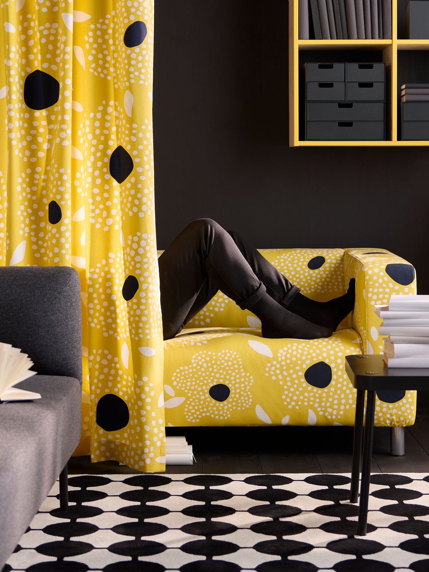 Es ist die Hälfte eines KLIPPAN Sofas zu sehen. Die andere Hälfte wird von einem Vorhang verdeckt. 