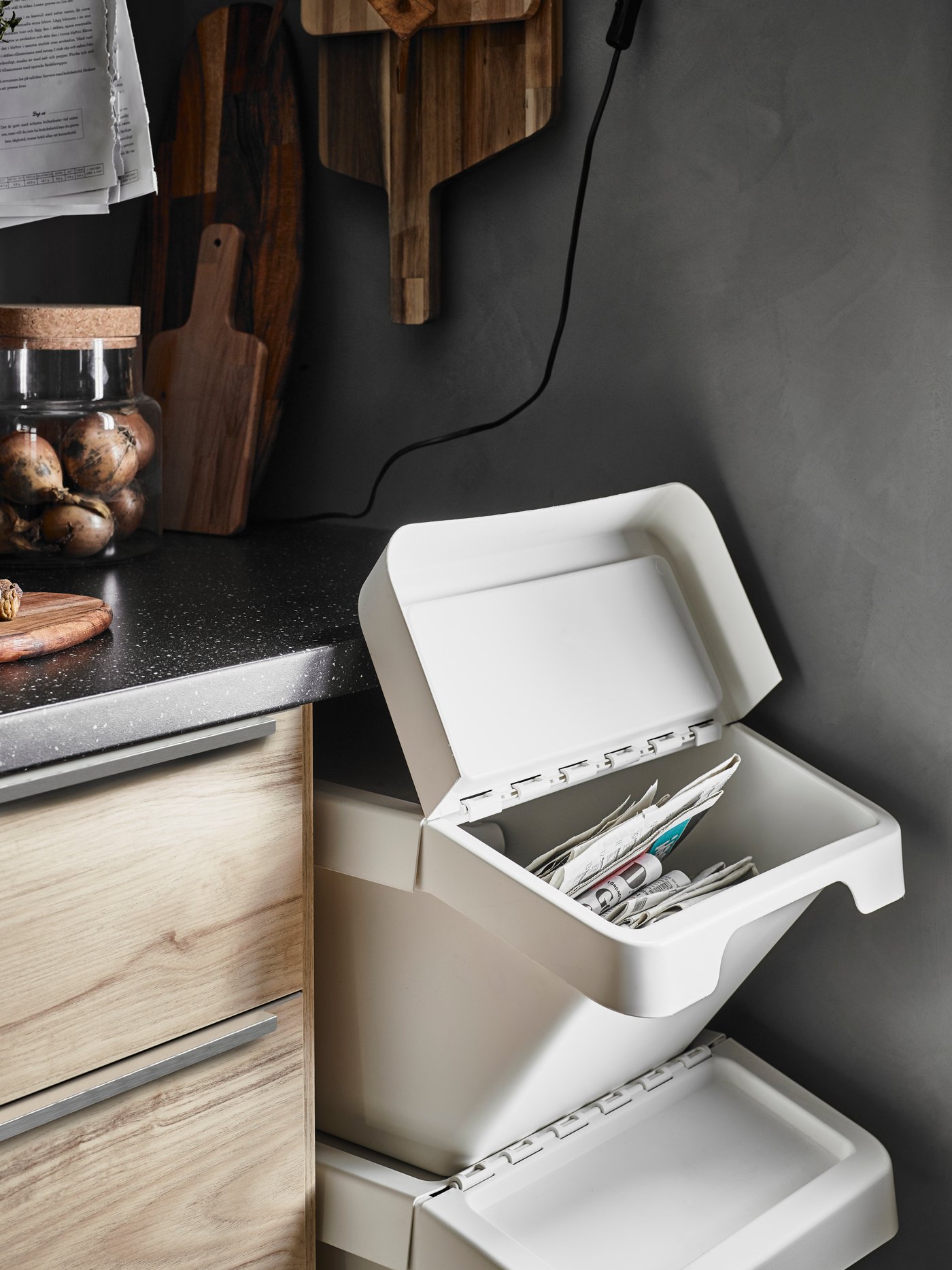 Mueble de cocina con pueras color madera ASKERSUND. Al costado derecho del mueble hay canecas de reciclaje.