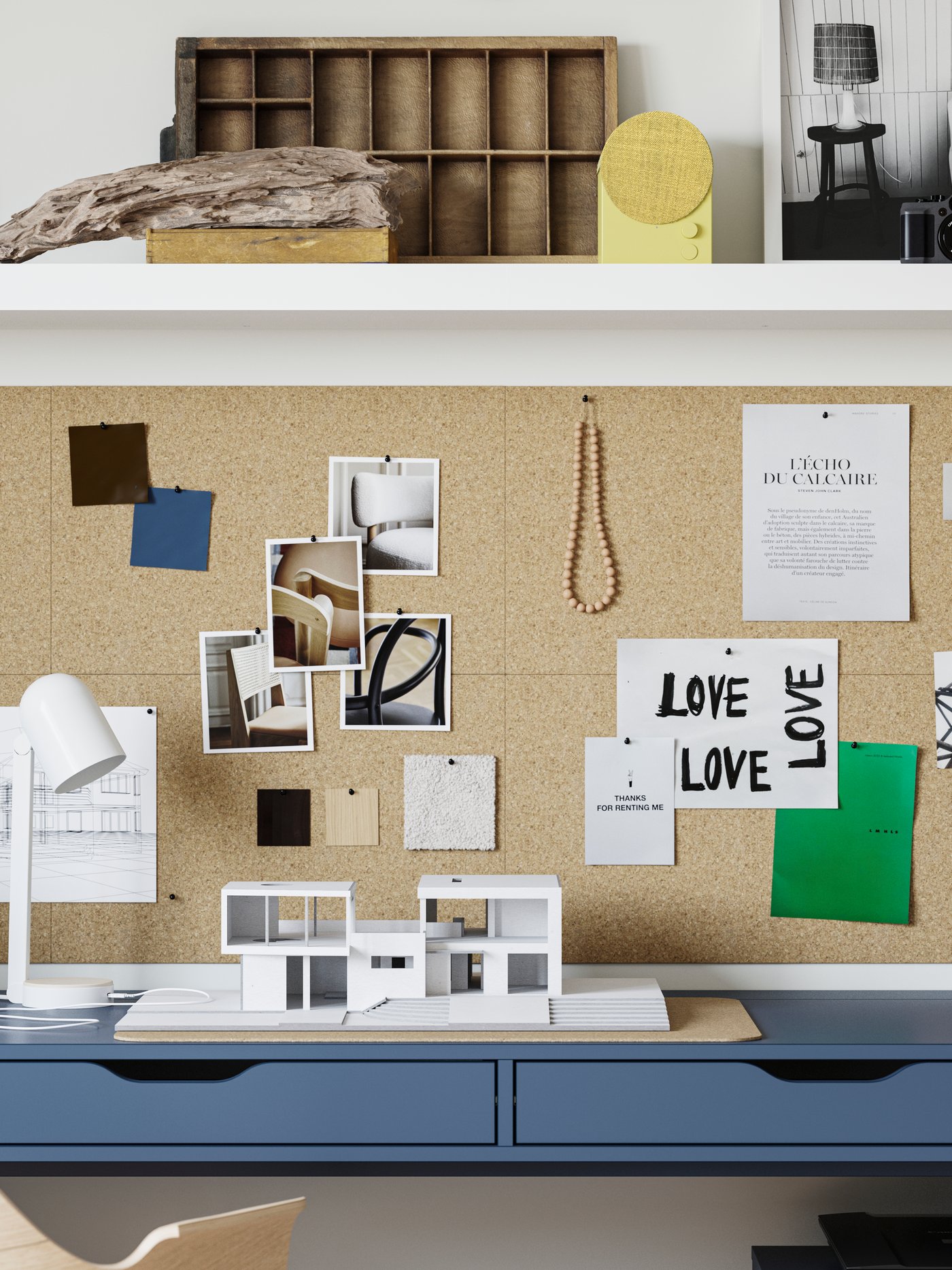A close-up of an ALEX desk in black-blue with a cork memo board hanging on the wall and a yellow speaker on the shelf above.