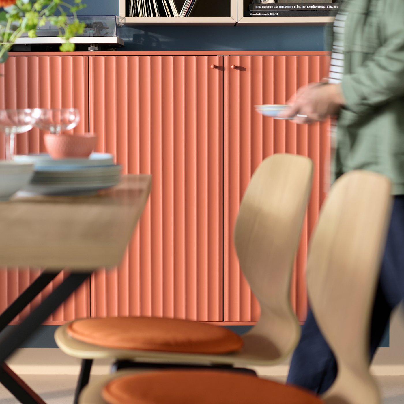 A close-up of a SKÅLSTA chair with a seat shell in oak veneer in a dining room with cabinets with TERRSJÖ accent doors.