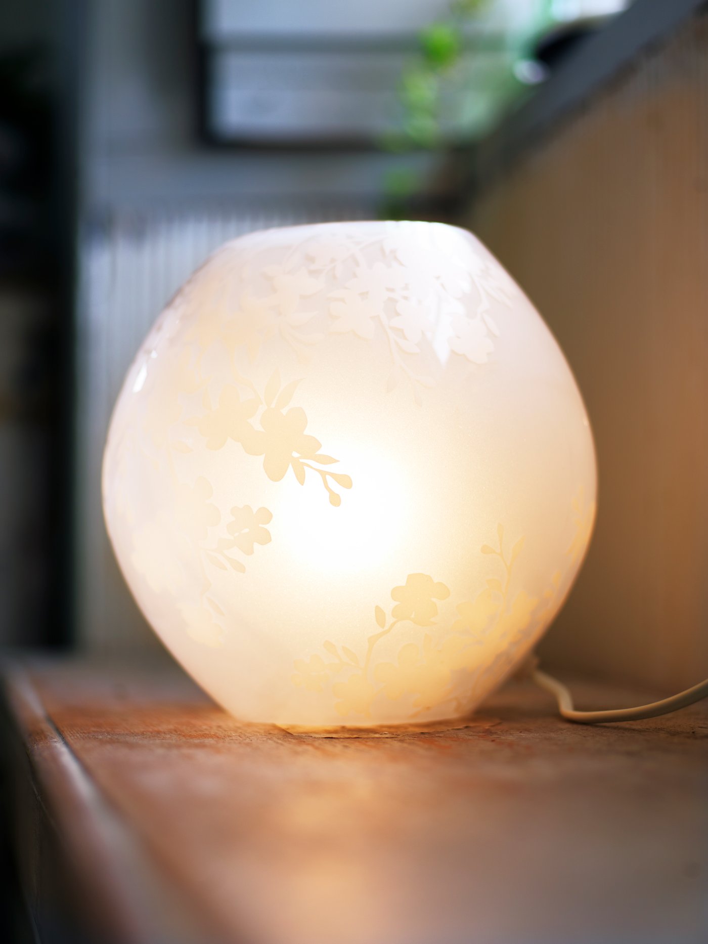 A cherry-blossoms white KNUBBIG table lamp