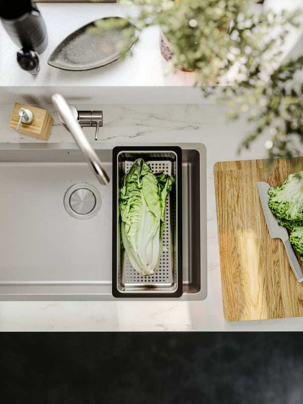 Fregadero de acero inoxidable VRESJÖN en una cocina luminosa, con un escurreplatos colocado encima.