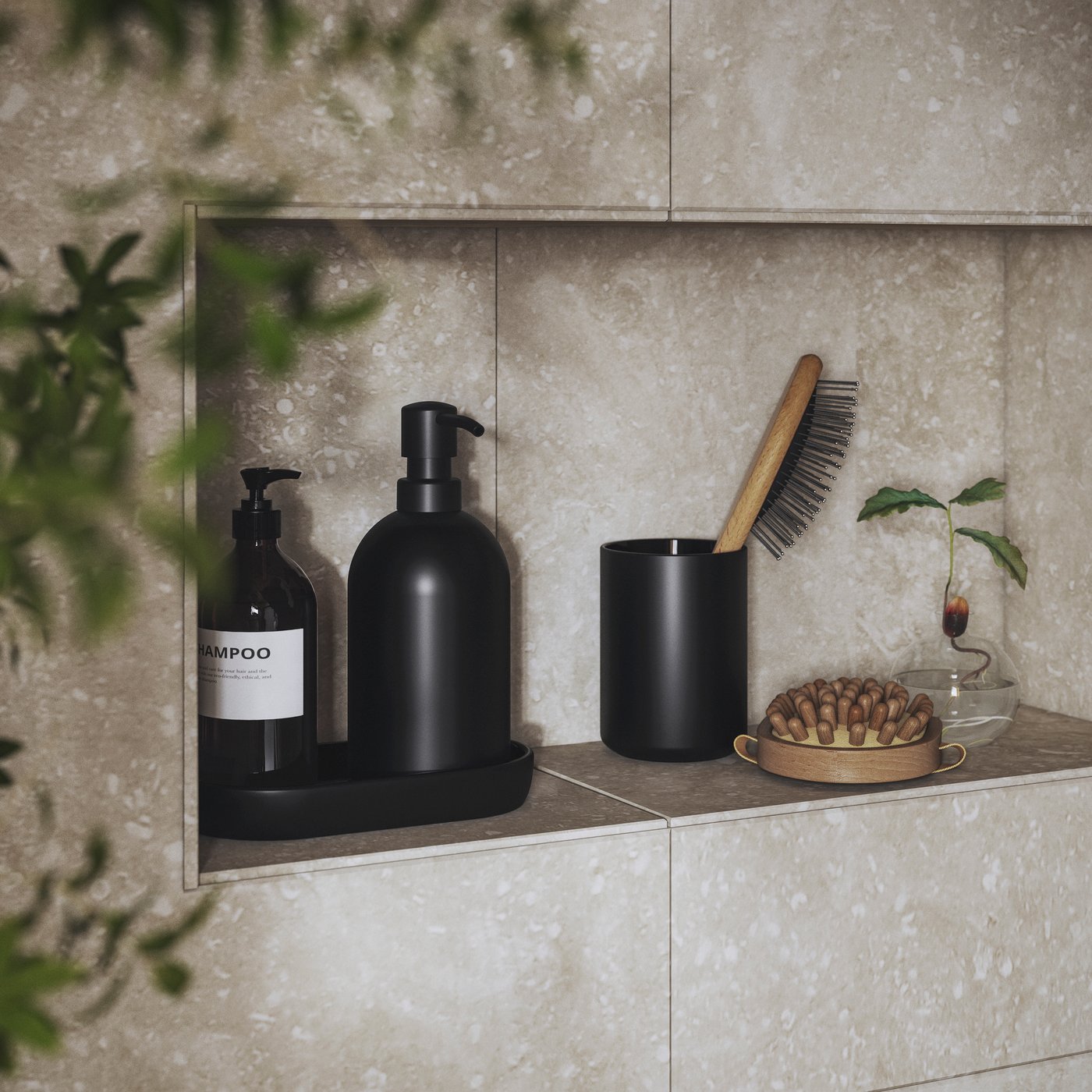 On a shower-side shelf stands a GANSJÖN 3-piece bathroom set in black with a soap dispenser, a tray and a toothbrush holder.