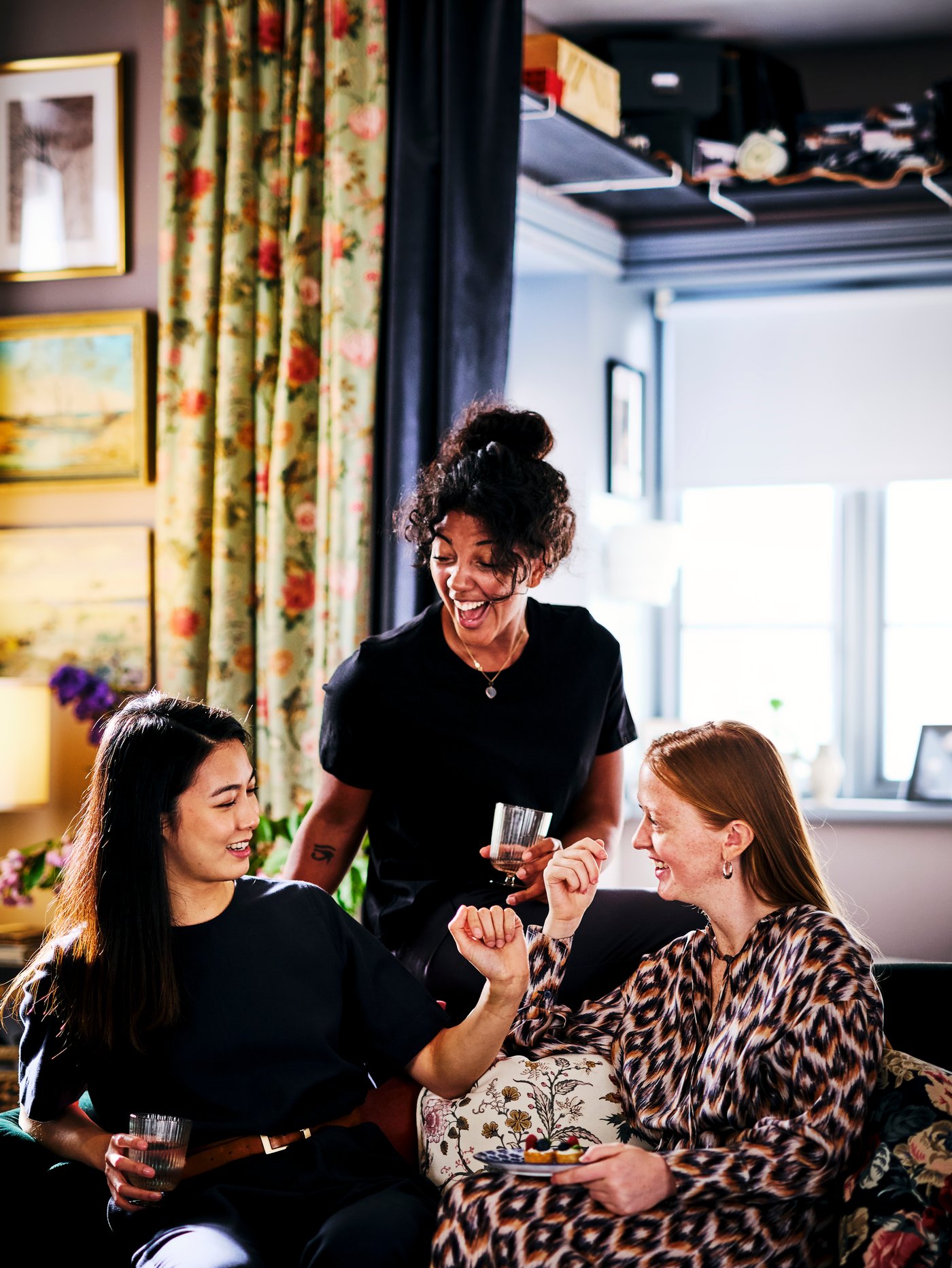 Trz kobiety siędzące na sofie i rozmawiające.