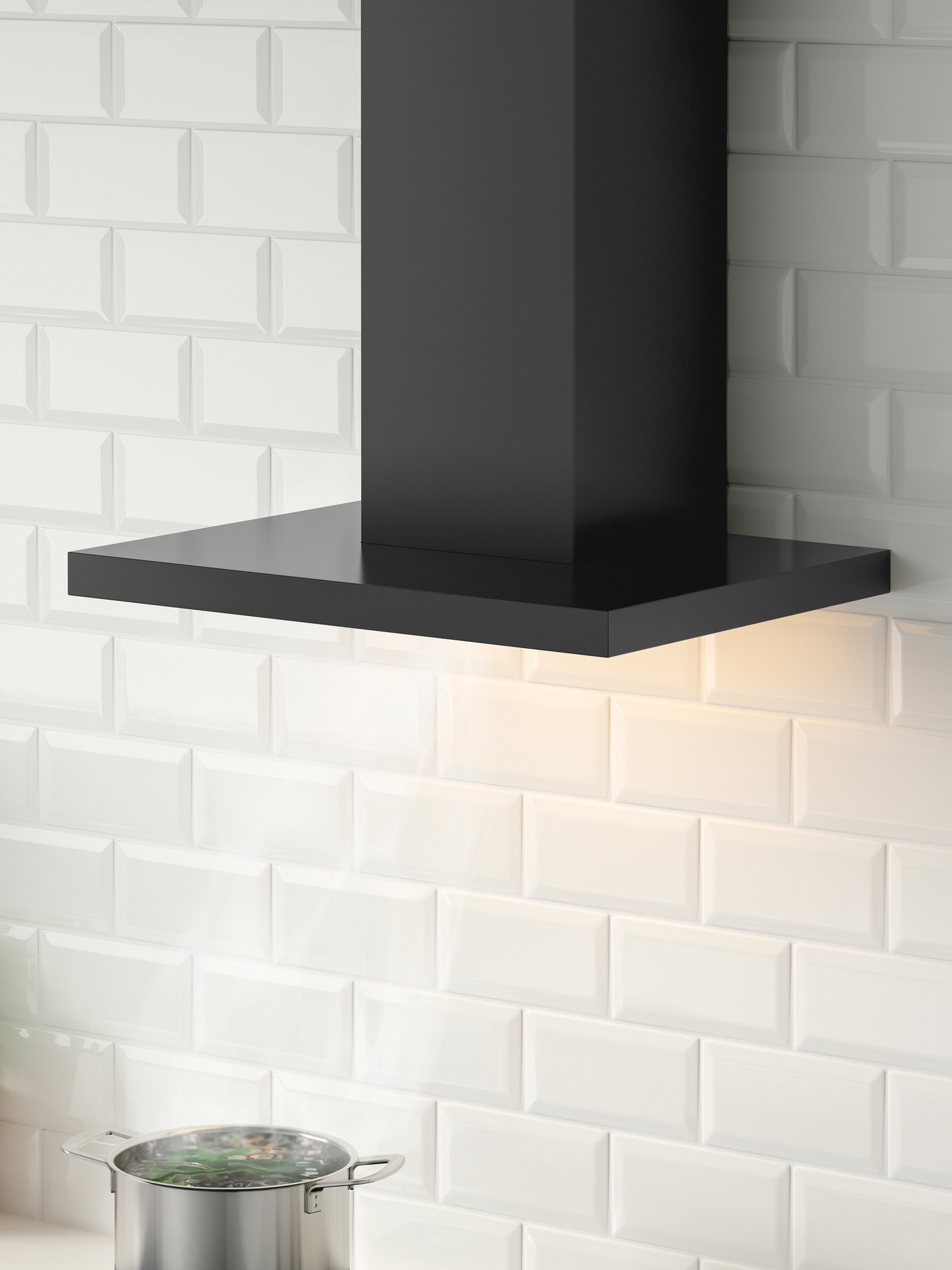 A MATÄLSKARE wall-mounted extractor hood in black, mounted on a white kitchen wall above a metallic pot.