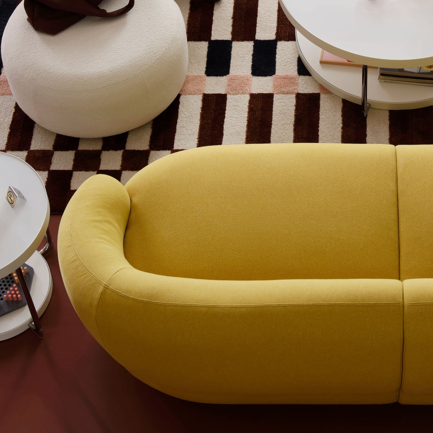 An off-white LILLESÄTER pouffe stands on a colourful rug near a bright green-yellow LILLESÄTER sofa.