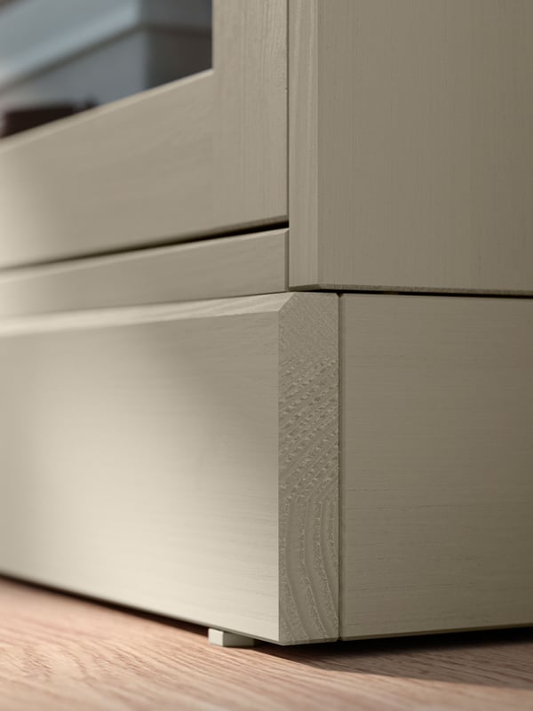 Szarobeżowy stolik kawowy HAVSTA ustawiony przed sofą na wzorzystym dywanie w pokoju dziennym.