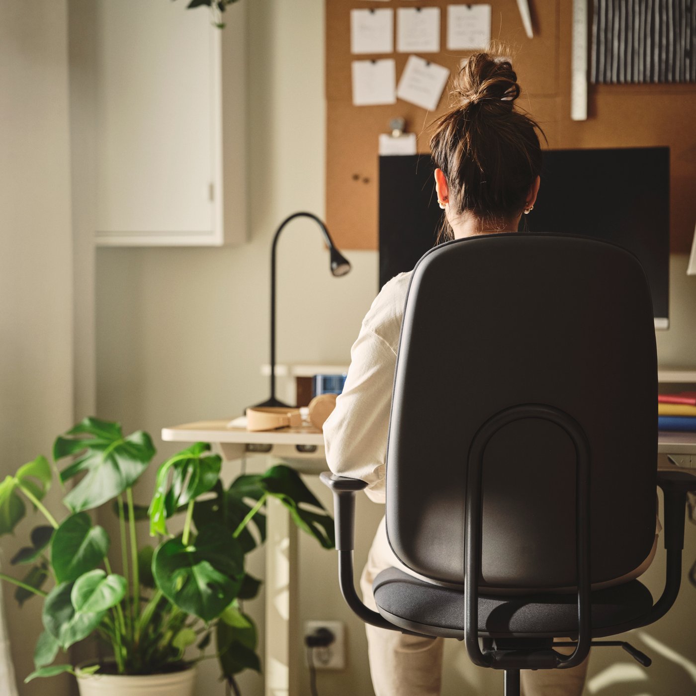 Person sitting with an ergonomic posture in a SMÖRKULL office chair.