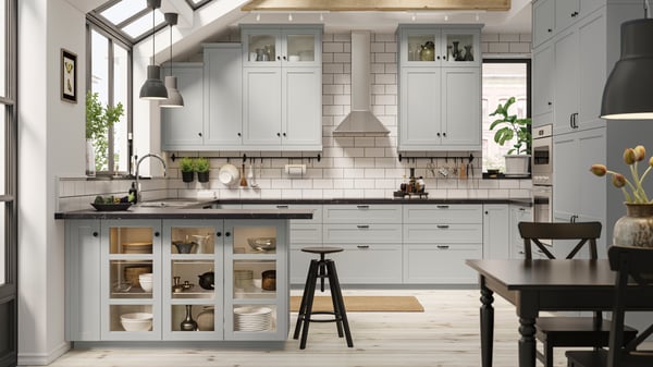 U shaped grey shaker kitchen with a white tile splashback in bright room with attached dining area