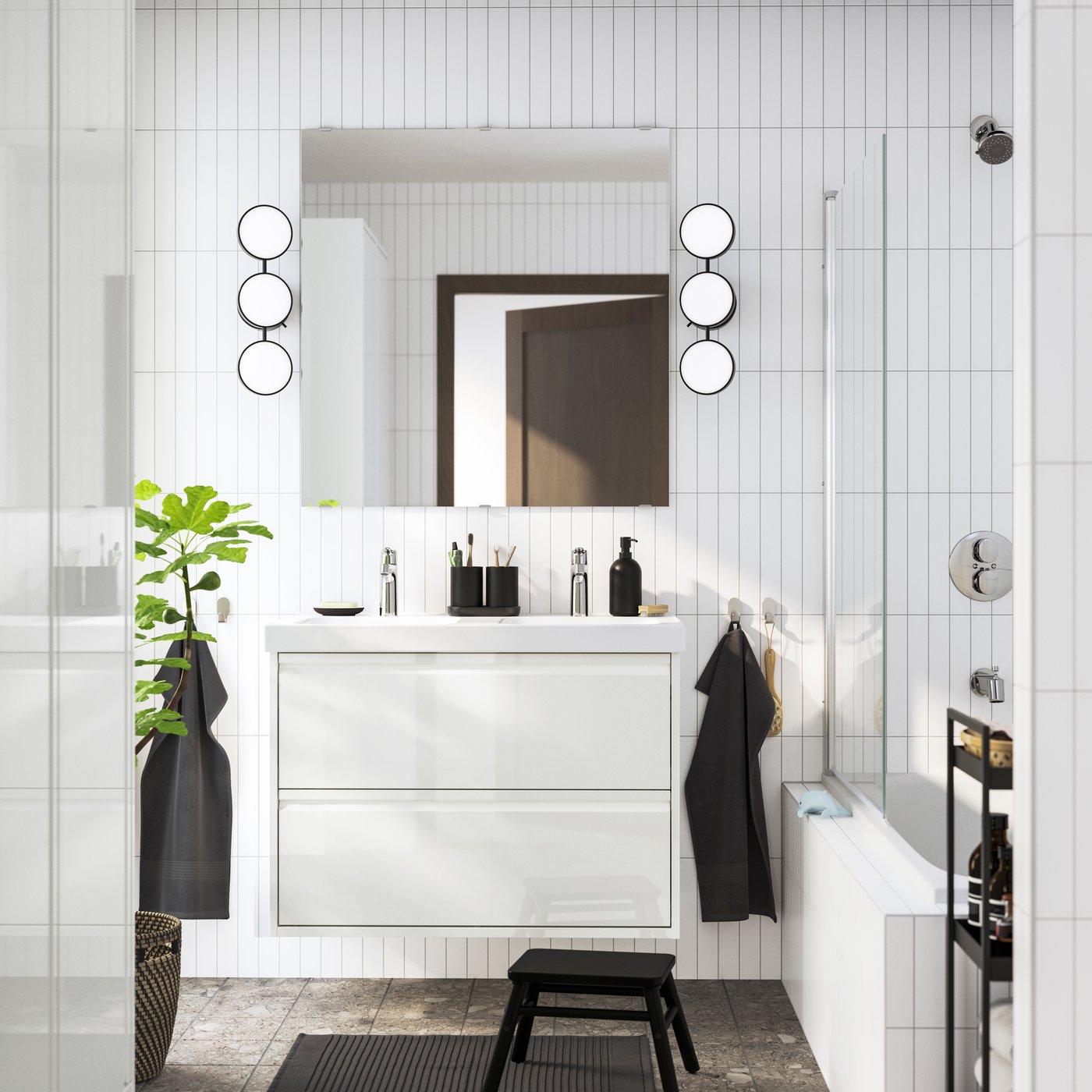 Modern white bathroom with a floating vanity, round wall lights and a glass‑panel bathtub.