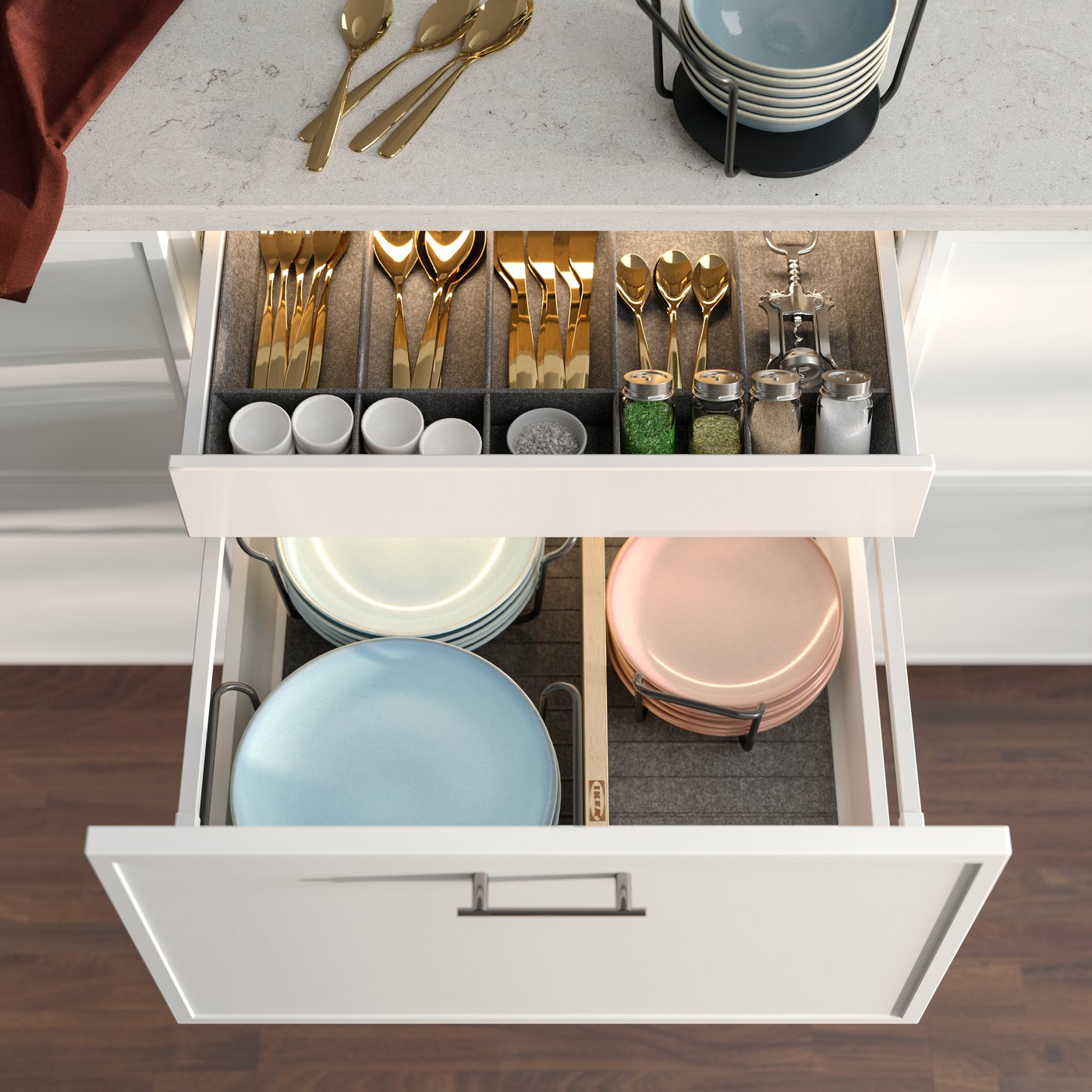 An opened  kitchen drawer  showing a grey UPPDATERA adjustable organiser filled with cutlery, utensils and spice jars.
