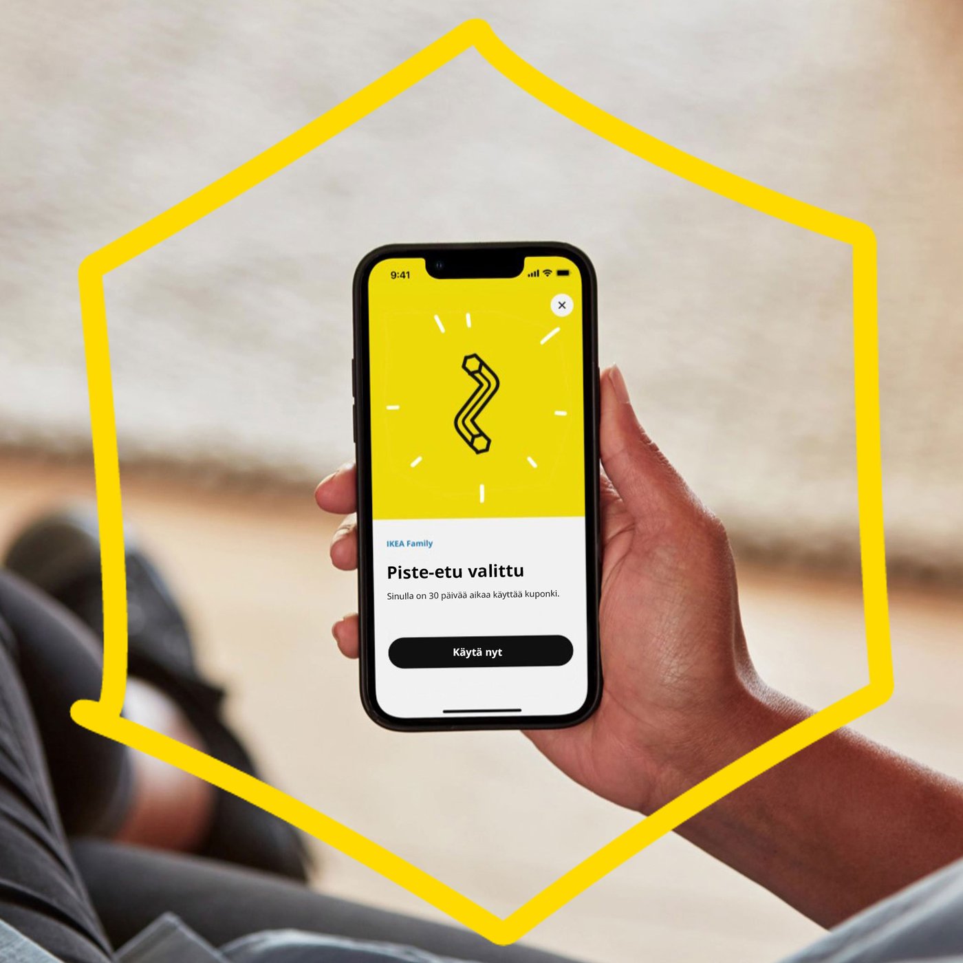 A hand is holding a phone with a drawing of an Allen key on a yellow background. 