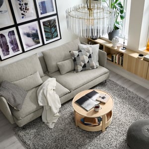 Bright living room with a sofa, round table and a large chandelier.