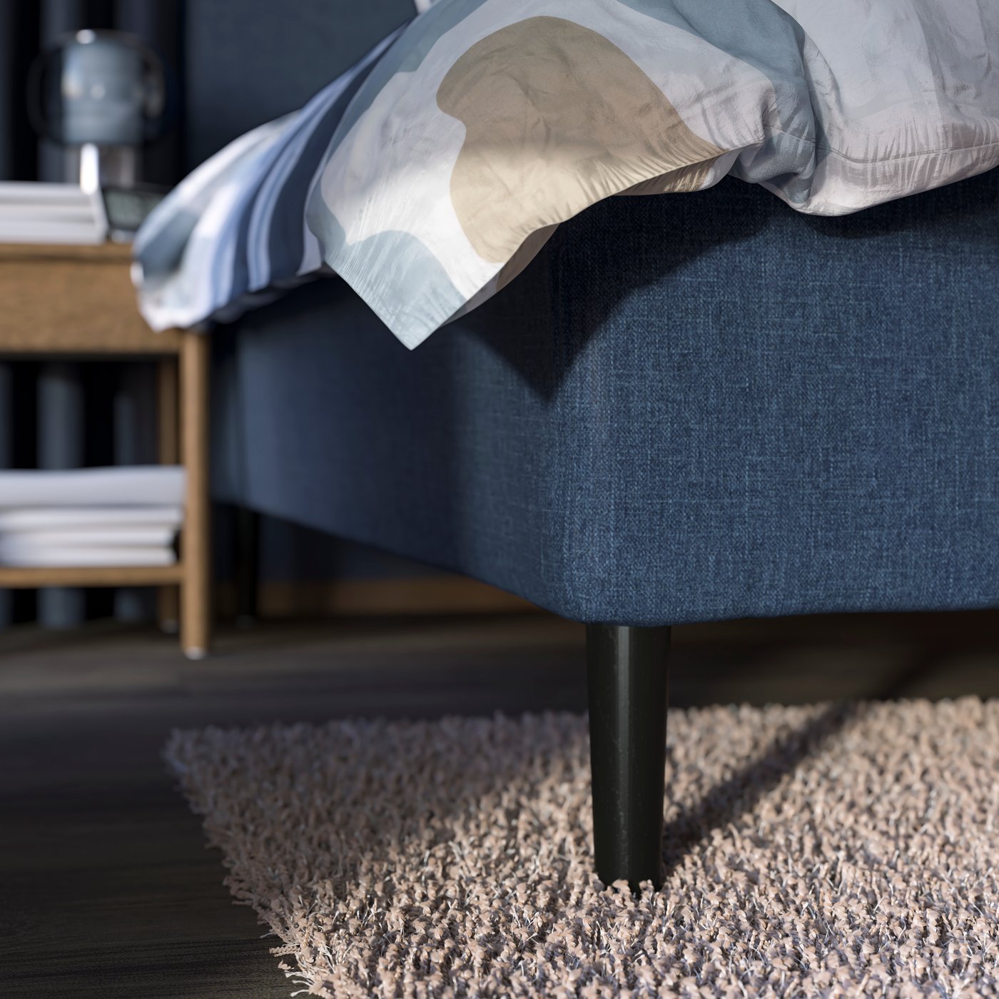 A pocket spring mattress base with BRYNILEN legs and MYGGLASVINGE bed linen stands in a bedroom on a VOLLERSLEV rug.