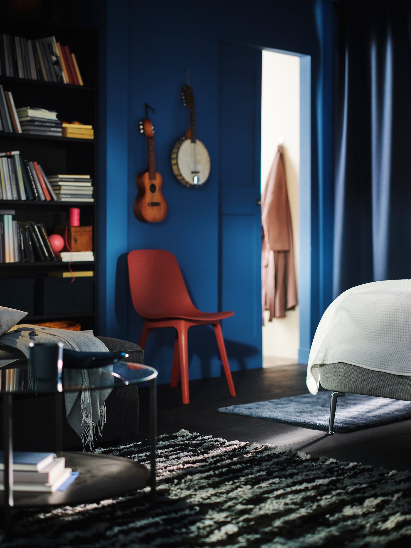 A black/grey/white BULLURREMSA high pile rug in a blue room TUFJORD upholstered bed that has a STOENSE rug by it.