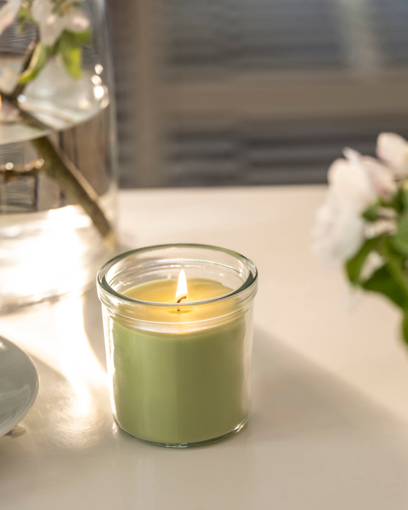 An Apple/light green LÖVSKOGSLUND scented candle in glass 