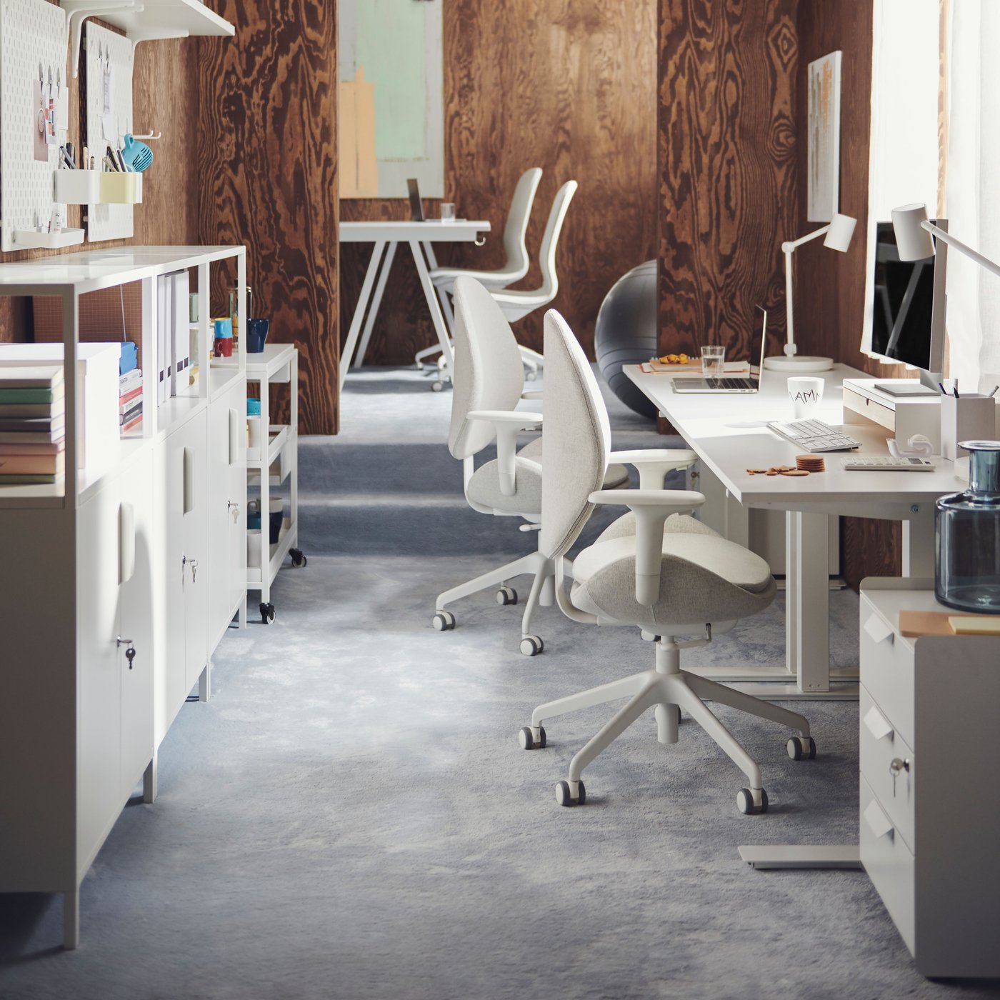 A small office space with white TROTTEN desks, TROTTEN cabinets, and LÅNGFJÄLL chairs.