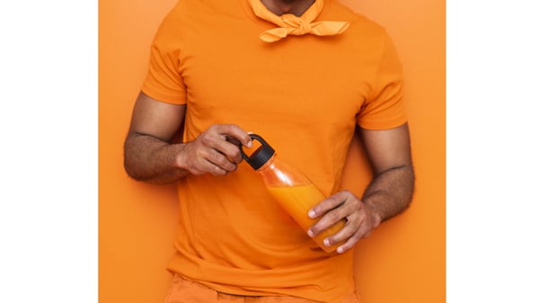 オレンジのタンブラーを持っている人