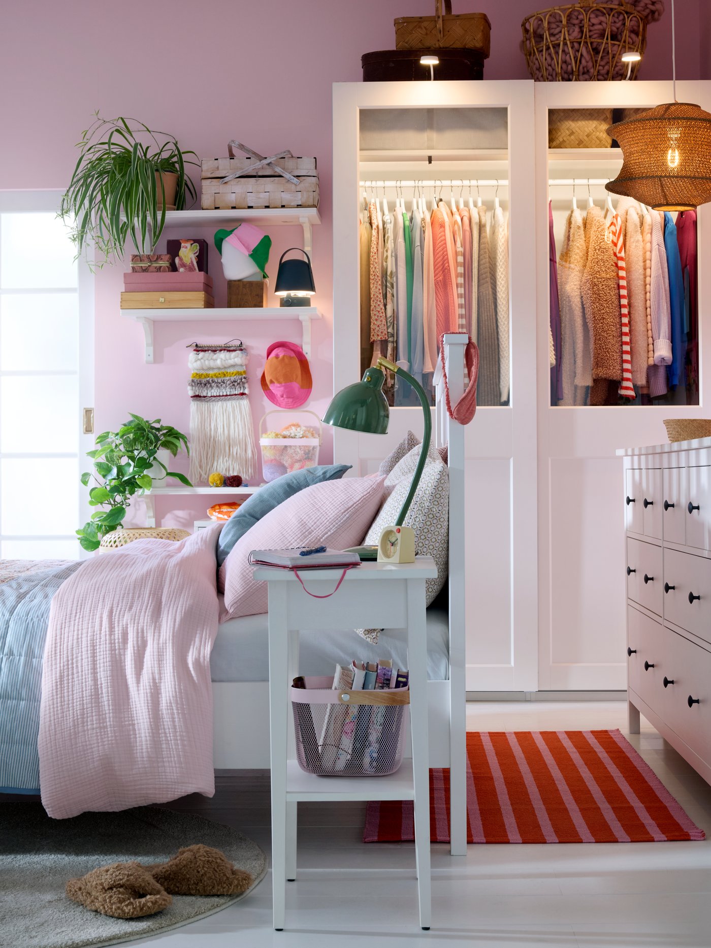 Bedroom with white HEMNES bed, bedside table and chest of drawers, pink walls and a PAX/GRIMO wardrobe in back.