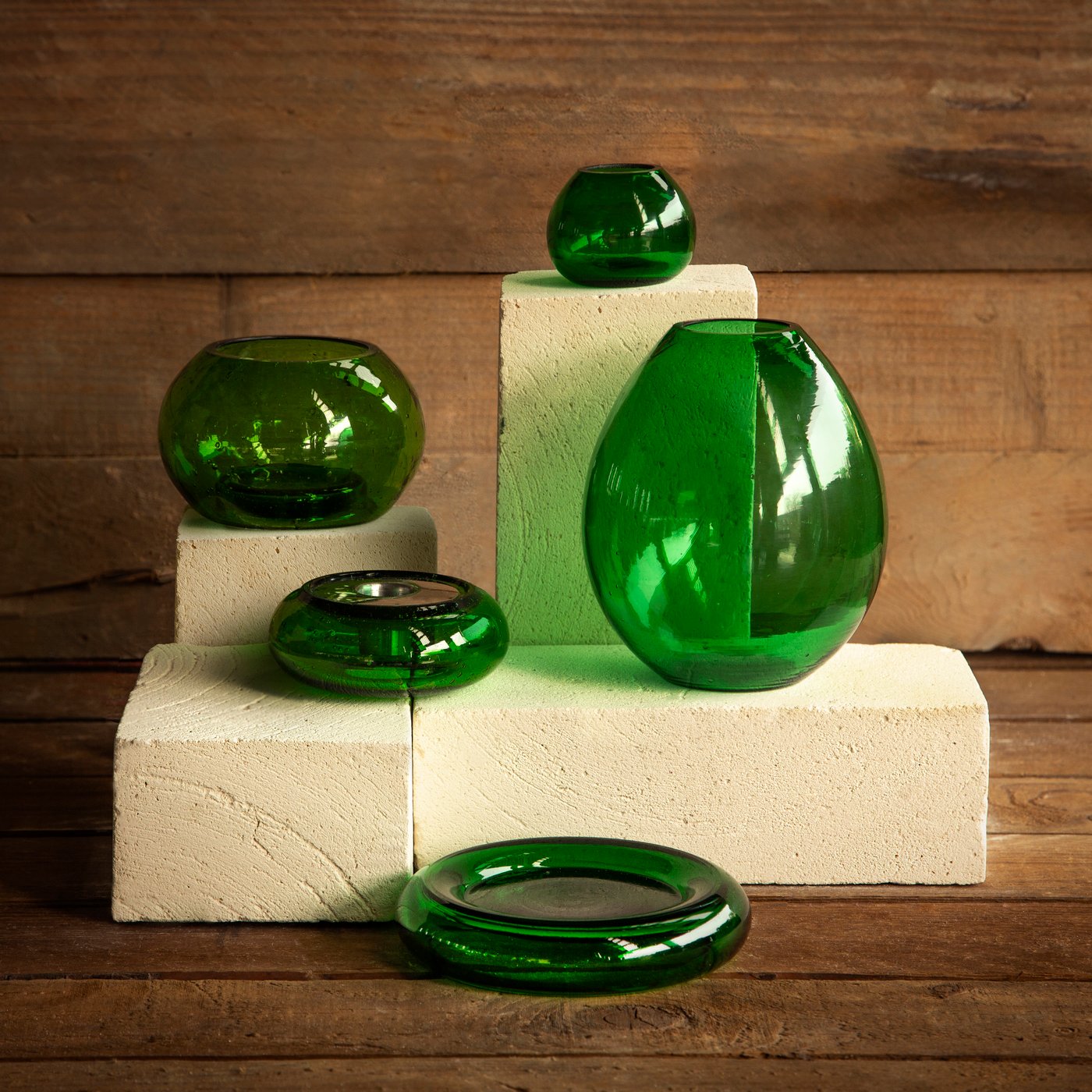 Grüne HÄNGBJÖRK Vasen und Kerzenständer stehen auf weißen Sockeln.