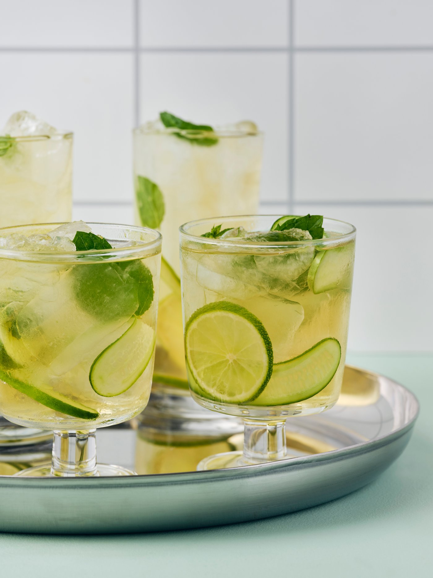 Various glasses on a tray with lemonade in it.